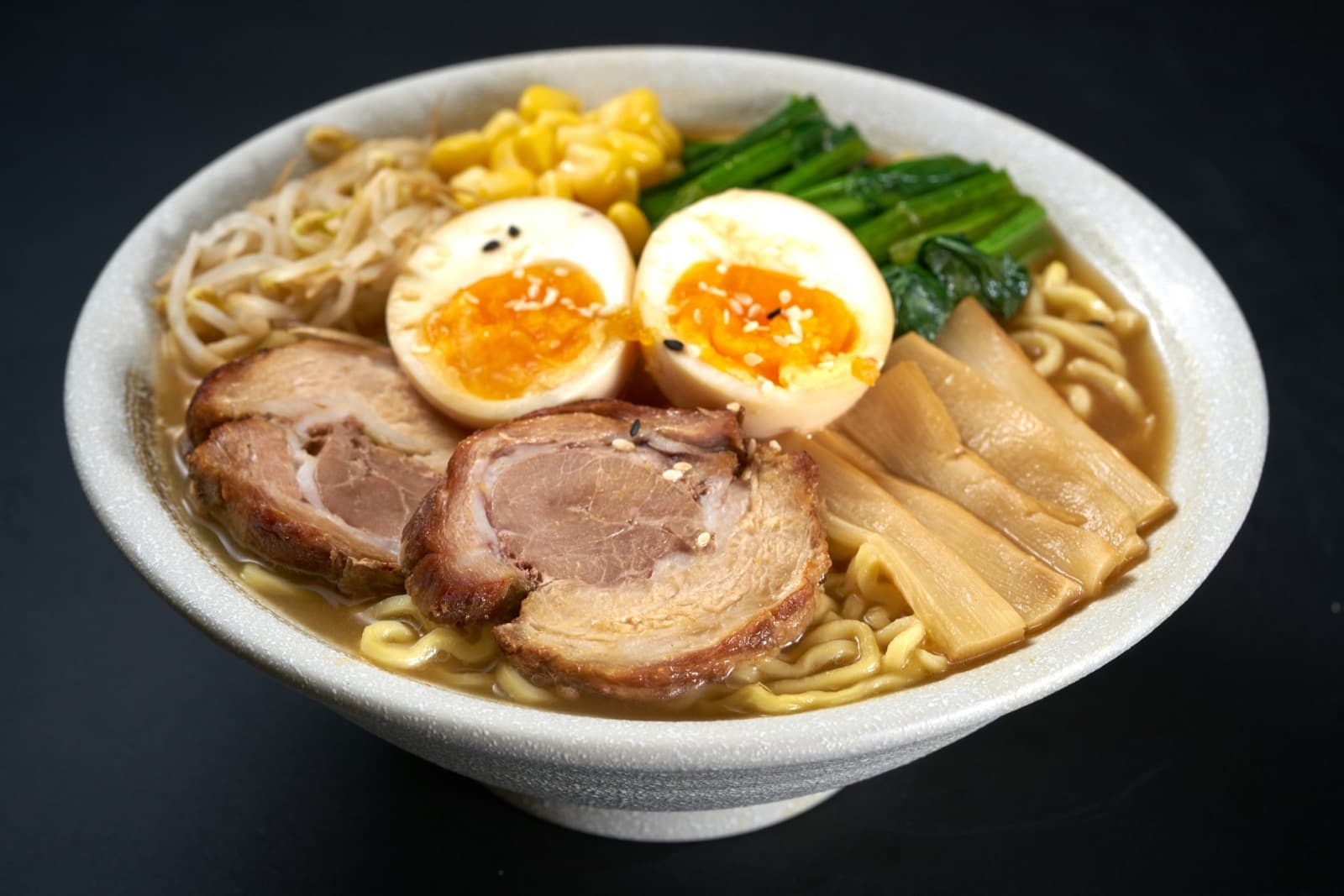 A bowl of ramen with soft eggs and chashu
