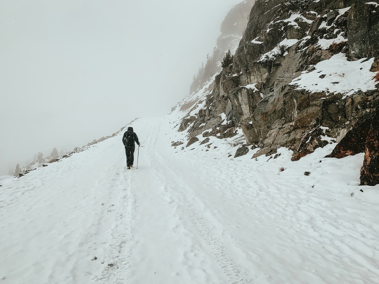A walker on a snow-walled trail in the Whistler alpine